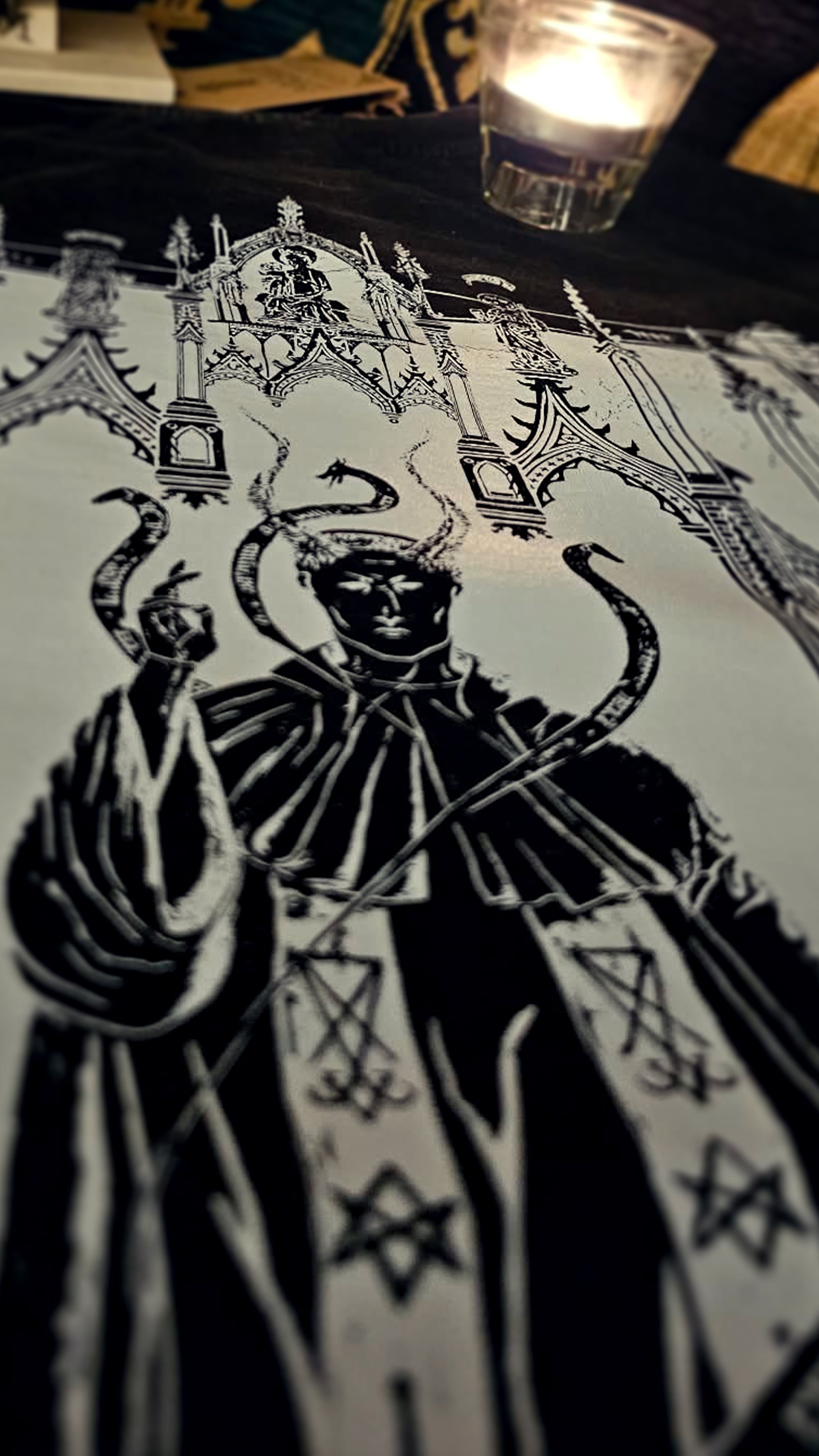 Decorative tablecloth with intricate black design on a dark surface