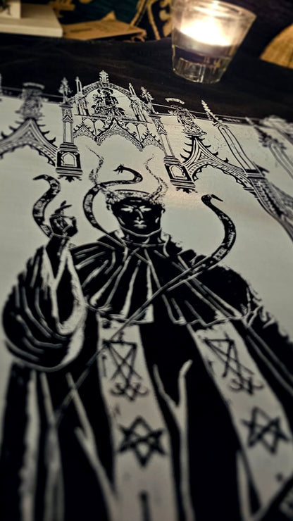 Decorative tablecloth with intricate black design on a dark surface
