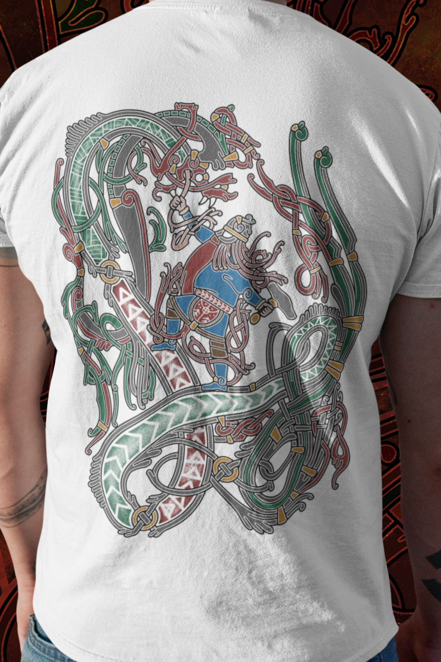 Person wearing a white t-shirt with a colorful dragon design on the back, standing against a dark, ornate background.
